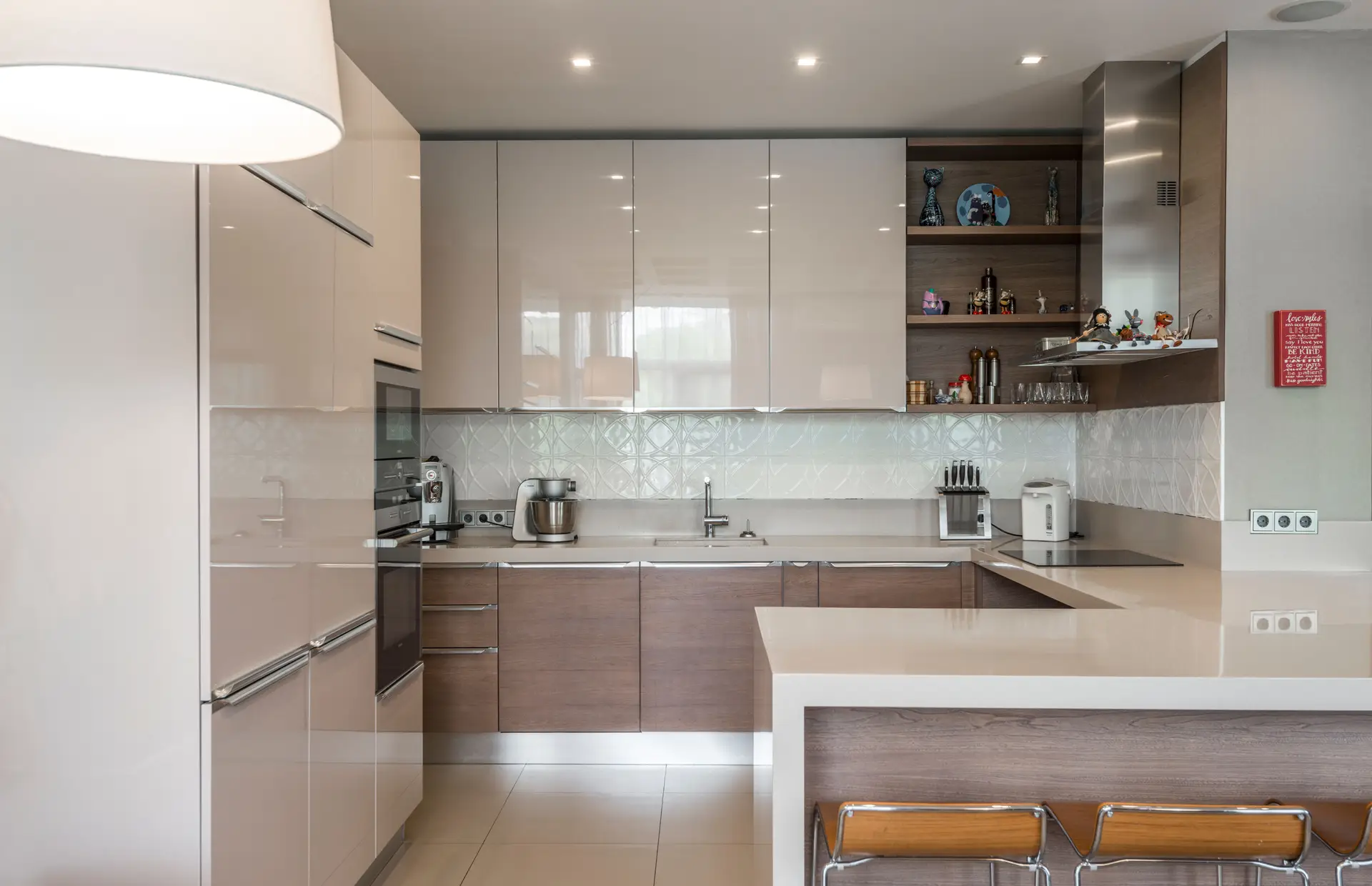Compact kitchen with a breakfast bar, pale upper cabinets and wood lower cabinets