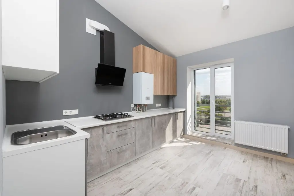Gray kitchen with wood lower cabinets and glass patio doors