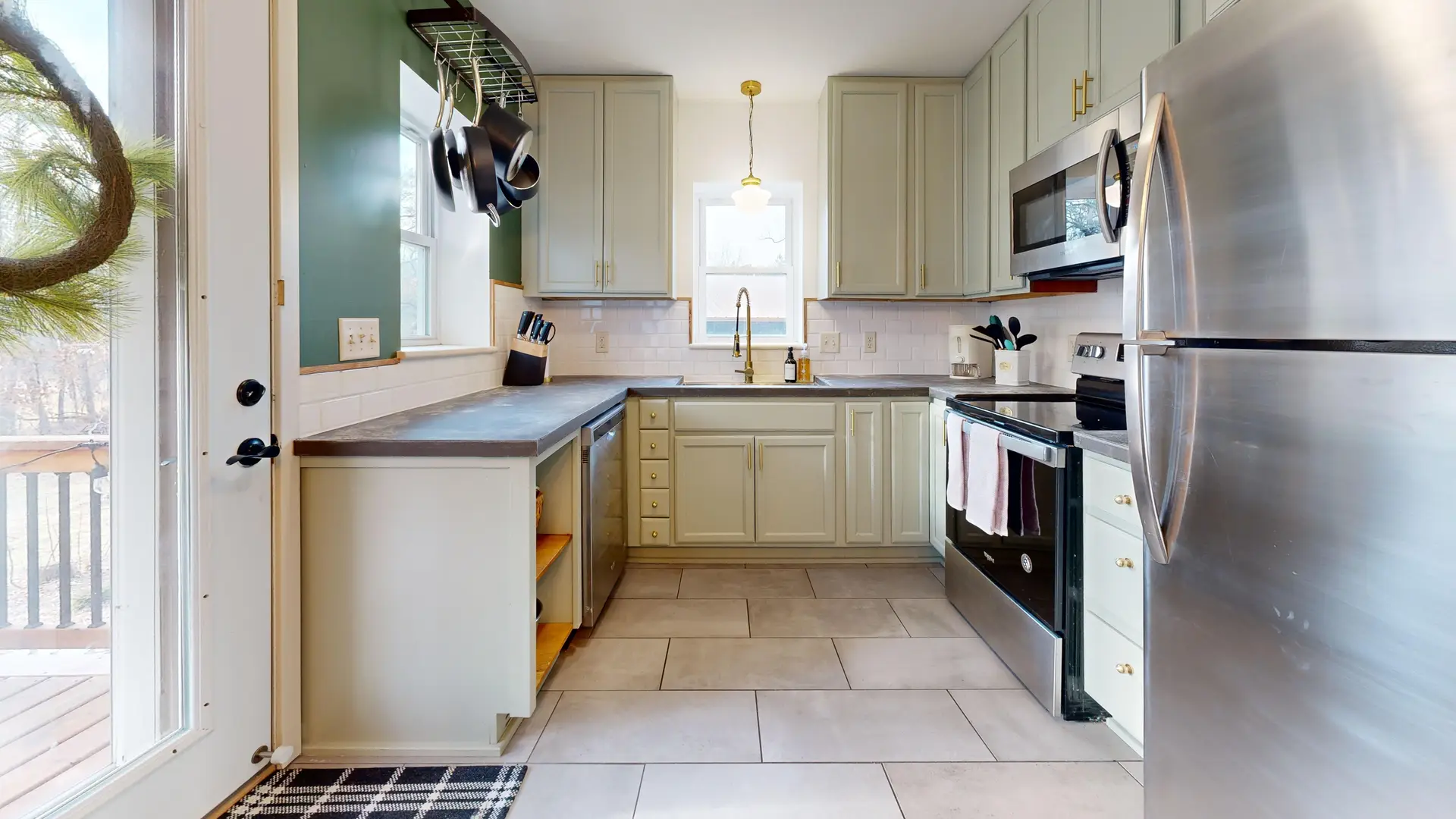 Kitchen with pale green cabinets and stainless steel appliances