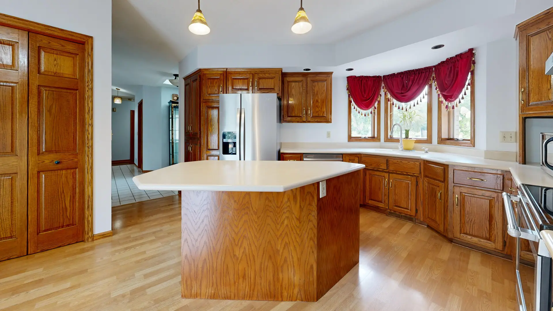Kitchen with wood cabinets, a central island and pendant lights